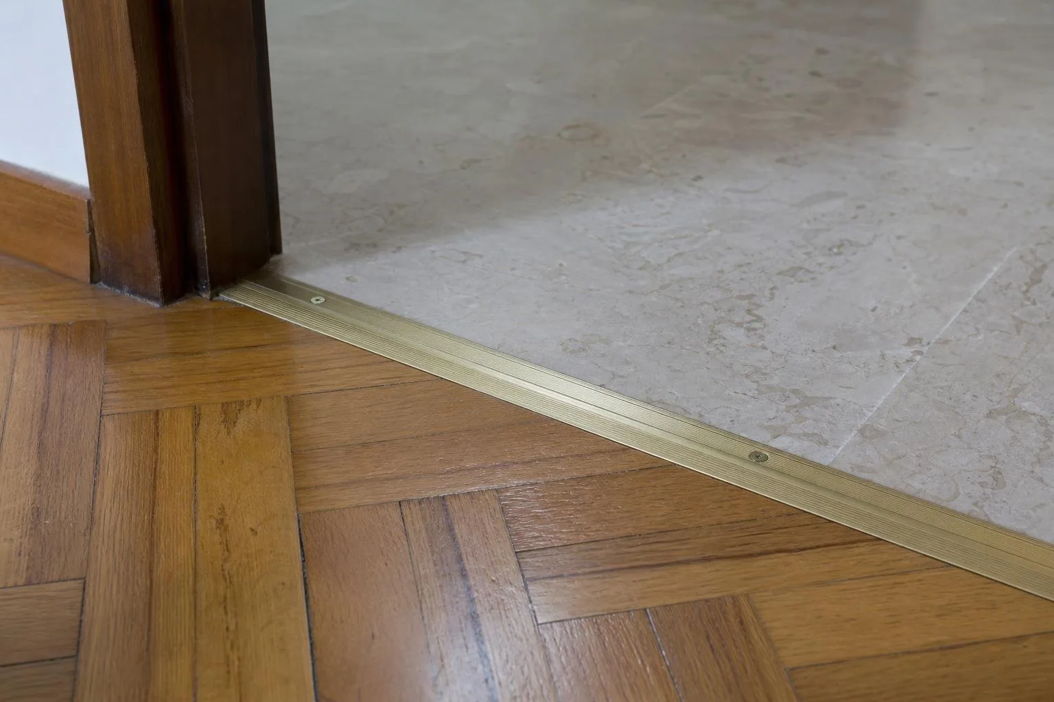 Encuentro de parquet y perfil de transición en una puerta