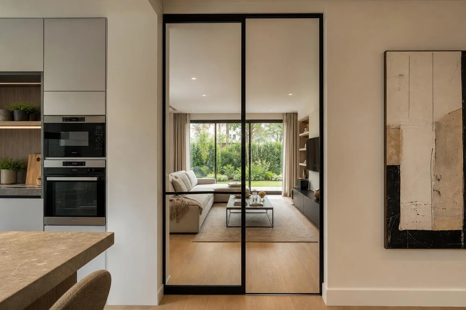 Puerta de vidrio con marco negro entre cocina y salón